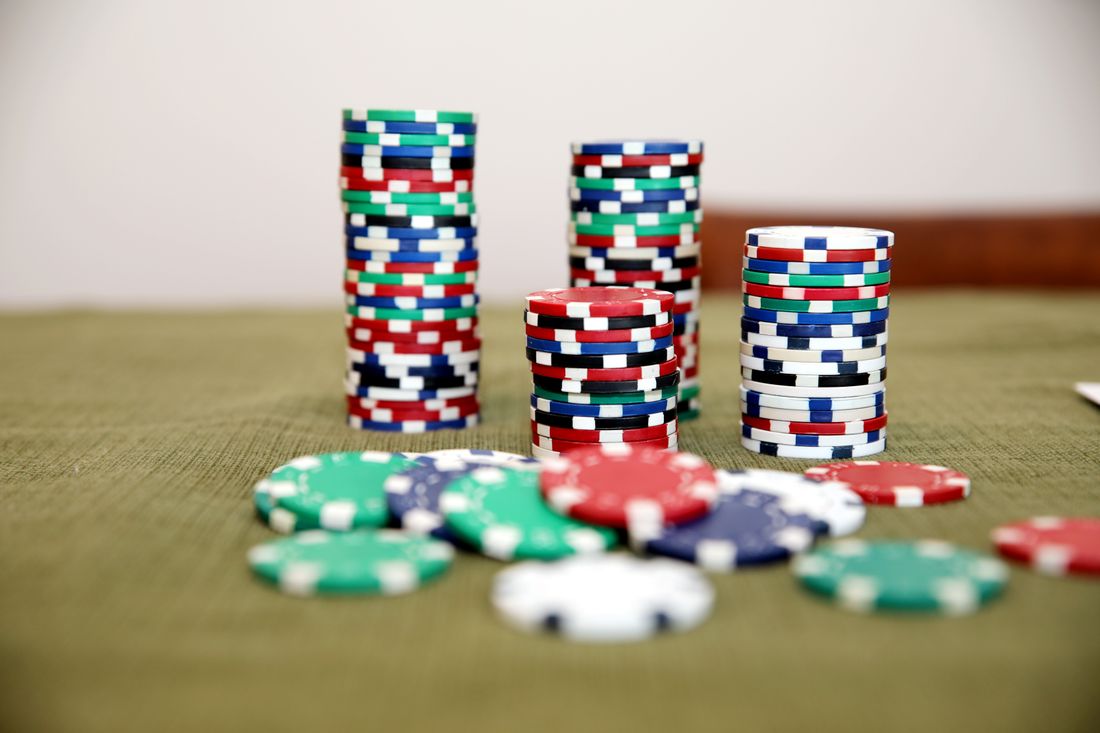 Chip poker bertumpuk di atas meja kasino sebagai ilustrasi panduan Megawin188